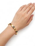 Hand wearing gold black clover charm bangle - Avenzra Black Clover Gold Bangle