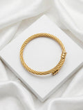 Golden twisted cable cuff bangle on white satin - Avenzra Golden Unisex Cuff Bangle