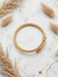Golden twisted cable bangle on marble with pampas grass - Avenzra Golden Unisex Cuff Bangle