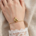 Delicate gold chain bracelet with heart charm worn on wrist - Avenzra Heart Charm Bracelet