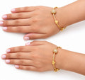 Two hands wearing pair of gold charm bangles with heart, flower and stone ball - Avenzra Gold Charm Bangle