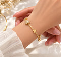 Slim gold charm bangle with heart and stone charms on wrist - Avenzra Gold Charm Bangle