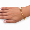 Gold charm bangle with heart and sparkling bead charm on wrist - Avenzra Gold Charm Bangle